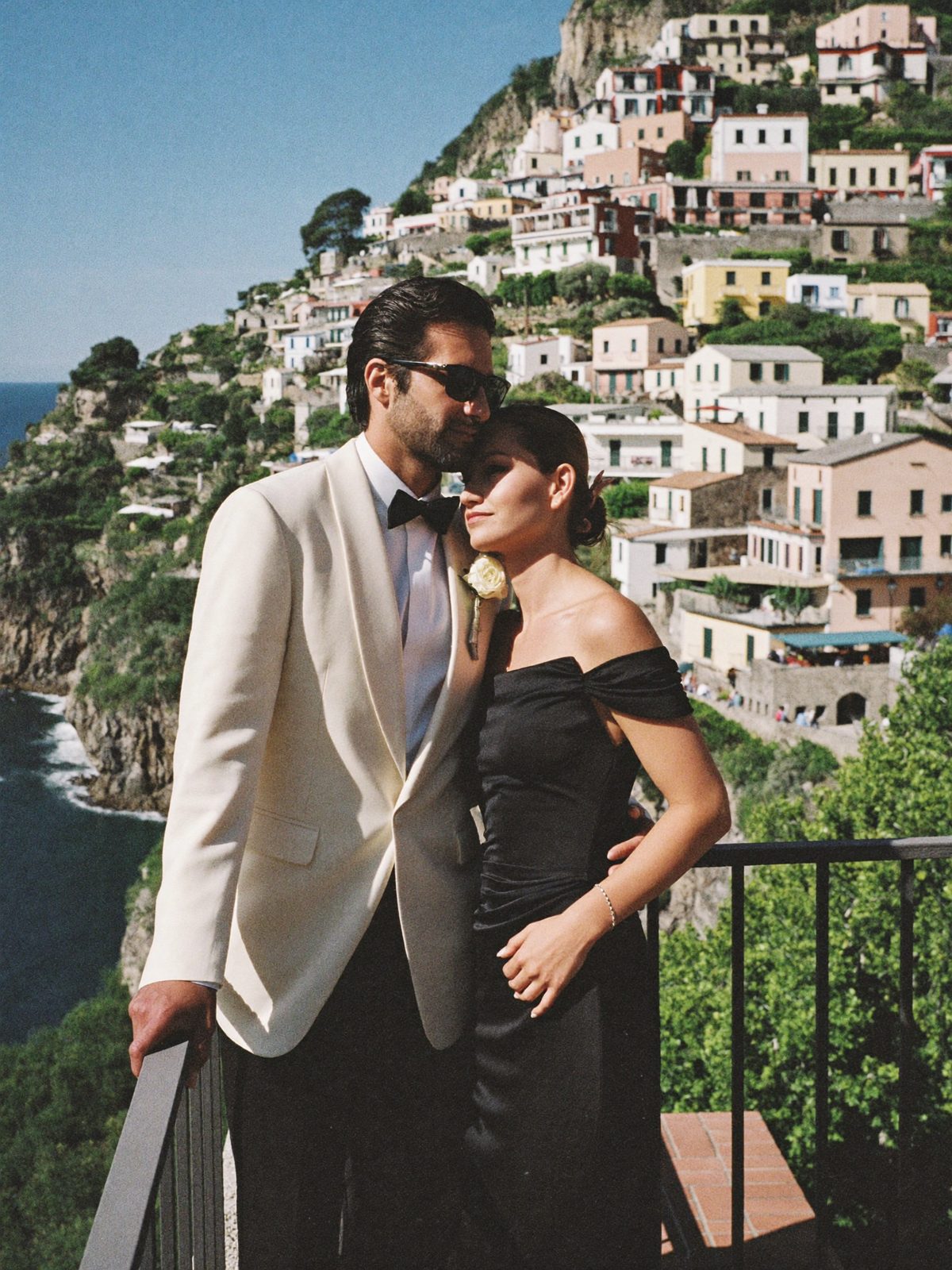A couple embracing on a cliffside terrace above Positano